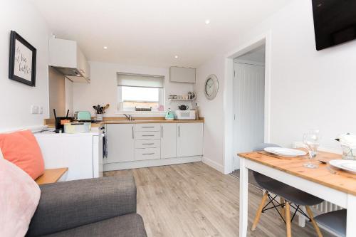 a kitchen and living room with a table and a couch at Jack's Hideaway in Gatehouse of Fleet