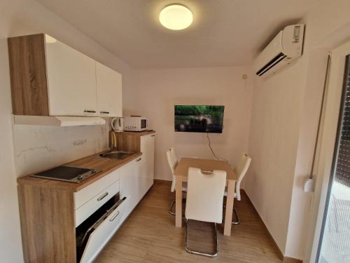 a small kitchen with a table and a small dining room at Apartmani Natalija 4 Stars in Mrljane