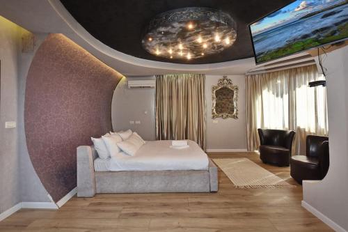 1 dormitorio con 1 cama y TV de pantalla plana en הרמוניה בכפר - וילה מהממת וגדולה עם ממ"ד, בריכה מחוממת וג'קוזי בגליל en ‘Ein el Asad