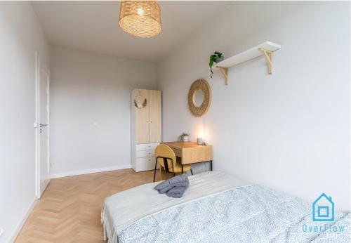 a white bedroom with a desk and a bed at Whizzy Room in Gdańsk