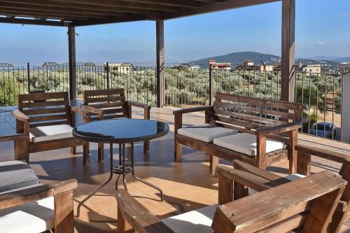 a patio with benches and a table with a view at הרמוניה בכפר - וילה מקסימה עם בריכה פרטית מחוממת וג'קוזי in ‘Ein el Asad