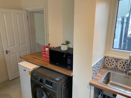a kitchen with a washing machine and a sink at Rainbow in London