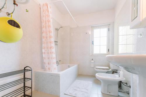 a bathroom with a tub and a toilet and a sink at Casa Antonietta in SantʼAnna Arresi