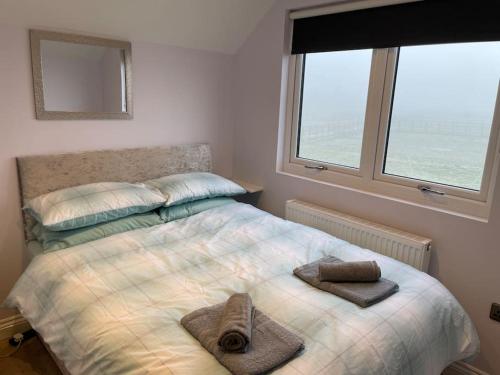 a bedroom with a bed with two towels on it at Appaloosa suite with amazing views of stud farm. in Great Driffield