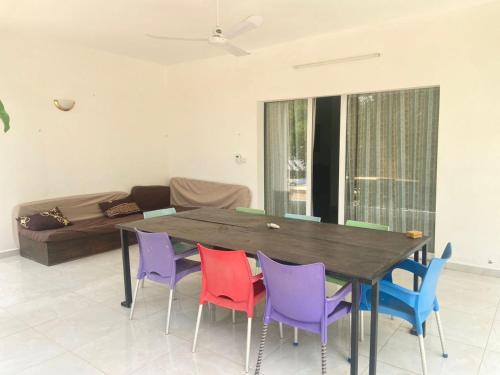 a dining room table with colorful chairs and a couch at CasaCanda king size in Somone