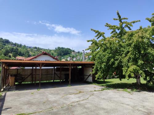 a building with a pavilion with a tree in front of it at Esma in Vogošća