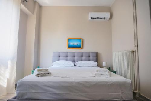 a bedroom with a large white bed with towels on it at Hotel Korfos - Ξενοδοχείο Κόρφος Renovated in Korfos