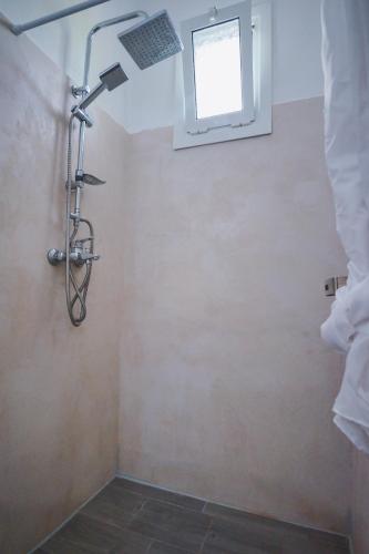 a shower in a bathroom with a window at Hotel Korfos - Ξενοδοχείο Κόρφος Renovated in Korfos