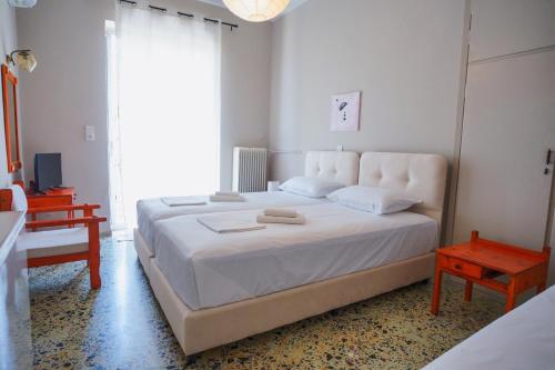 a bedroom with a large white bed and a table at Hotel Korfos - Ξενοδοχείο Κόρφος Renovated in Korfos