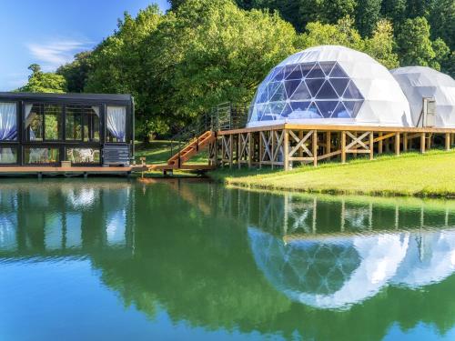a large dome building next to a body of water at GLAMP ELEMENT(グランエレメント） in Maibara
