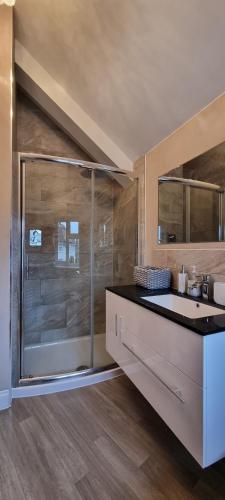 a bathroom with a glass shower and a sink at Walnut Tree View in Oxford