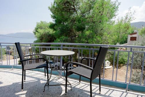 a table and two chairs sitting on a balcony at Hotel Korfos - Ξενοδοχείο Κόρφος Renovated in Korfos