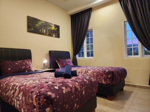 a bedroom with two beds and two windows at Fathers Guesthouse Age 7 years old and above only in Tanah Rata