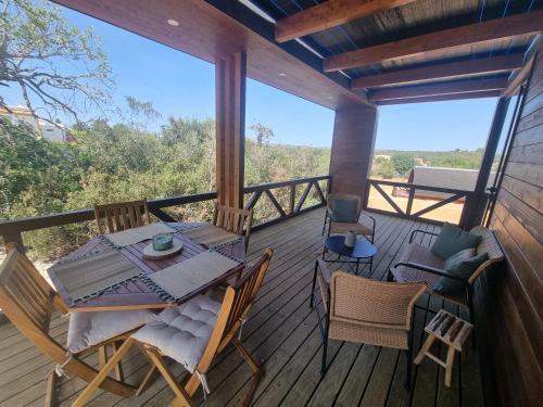 a wooden deck with a table and chairs on it at Eco Lodge Villa das Alfarrobas com Piscina in Algoz