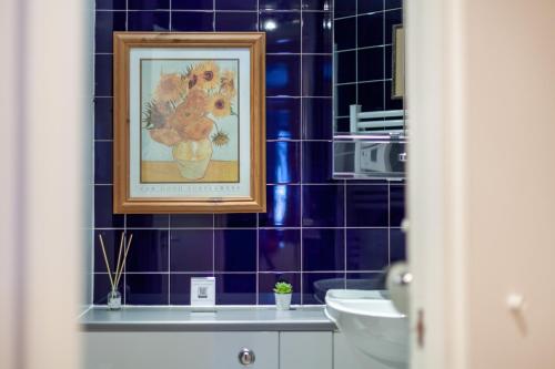 a picture of a bathroom with a painting on the wall at Lovely Studio in Tower Hill, Fantastic location in London