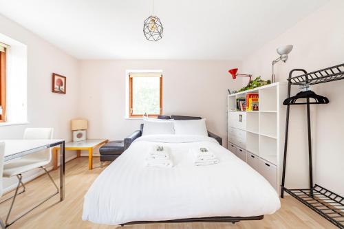 ein weißes Schlafzimmer mit einem Bett und einem Schreibtisch in der Unterkunft Lovely Studio in Tower Hill, Fantastic location in London