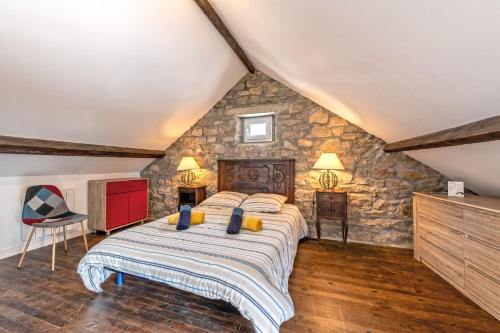 a bedroom with a bed and a stone wall at KerMad - Maison avec jardin in Le Relecq-Kerhuon