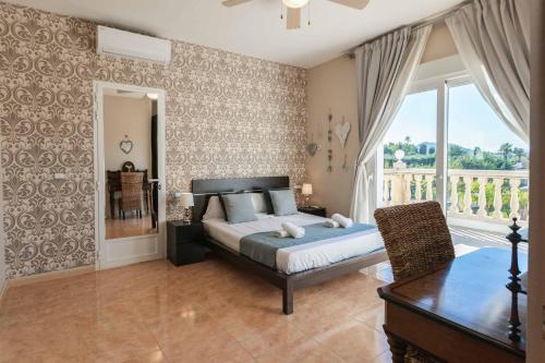- une chambre avec un lit, une table et une fenêtre dans l'établissement Villa Paulina Javea, à Jávea