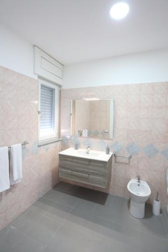 uma casa de banho com um lavatório, um WC e um espelho. em Il Giglio em Castel Volturno