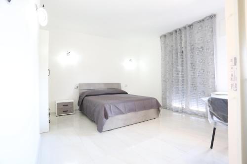 um quarto branco com uma cama e uma janela em Il Giglio em Castel Volturno