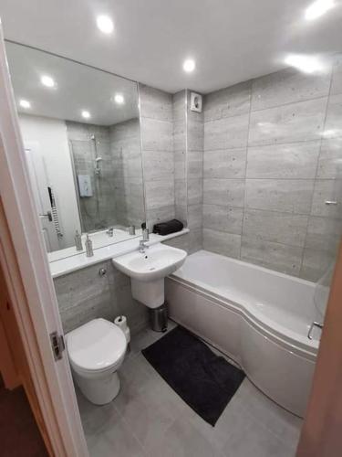een badkamer met een wastafel, een bad en een toilet bij Slateford Road Modern Apartment in Edinburgh