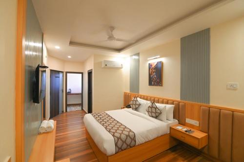 a hotel room with a bed and a television at Hotel Swagat Suites in Haridwār