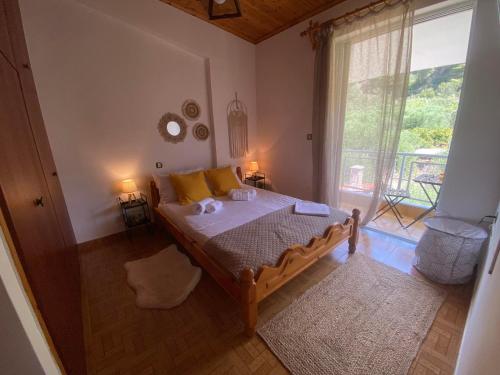 Un dormitorio con una cama con almohadas amarillas y una ventana en homonatura. sense of native living., en Pyrgos