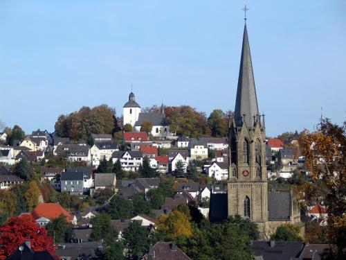 an old church with a steeple in a town at Landhotel Püster in Allagen