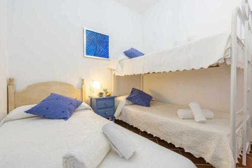a bedroom with two bunk beds with blue pillows at Casa Rural Villa Felisa in La Puebla de Cazalla