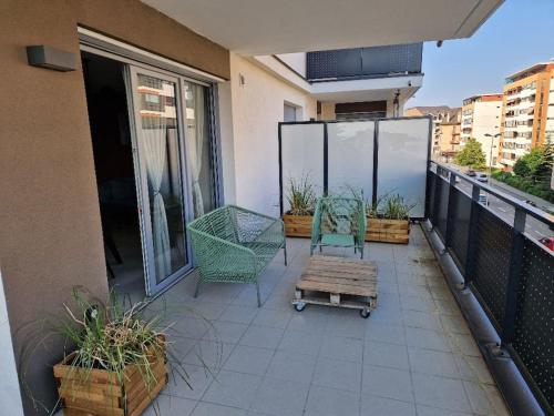 un balcon avec deux chaises et une table sur un immeuble dans l'établissement Casa Rosa T3 centre ville, à Thonon-les-Bains