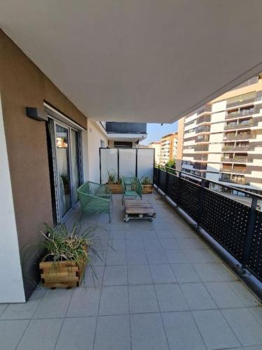 d'un balcon avec des chaises et des tables. dans l'établissement Casa Rosa T3 centre ville, à Thonon-les-Bains