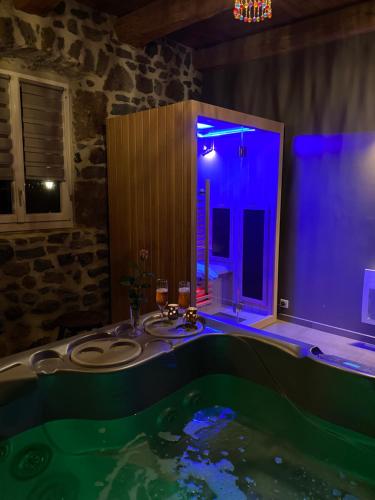 een badkamer met een groot bad met blauwe verlichting bij Suite privative sur Domaine Au chant de l'eau avec possibilité séjour bien-être in Siaugues Ste Marie