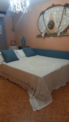 een slaapkamer met een bed met een tafel en een kroonluchter bij LA MIA CASA DI CAMPAGNA MARIA in Santa Giustina