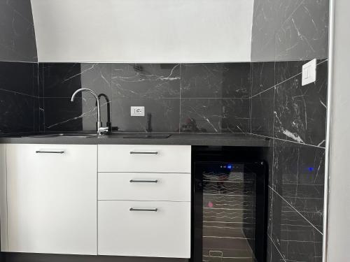 a kitchen with white cabinets and a black wall at SUITE 1 in Palo del Colle