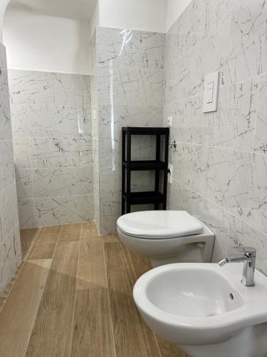 a bathroom with a white toilet and a sink at SUITE 1 in Palo del Colle
