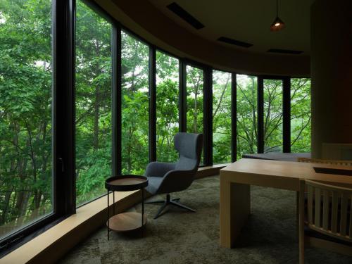a room with a desk and a chair and windows at Suigan in Jozankei