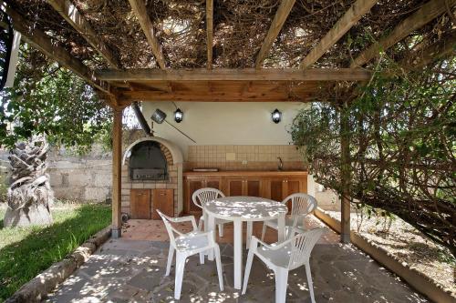 a patio with a table and chairs under a pergola at Las Tres Palmeras in Güimar
