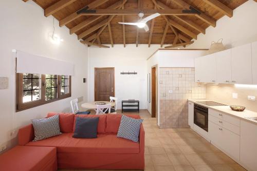 a living room with a red couch and a kitchen at Las Tres Palmeras in Güimar