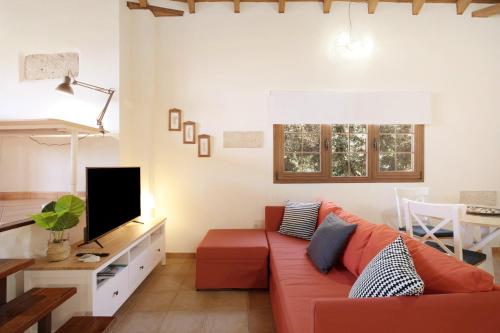 a living room with a red couch and a tv at Las Tres Palmeras in Güimar