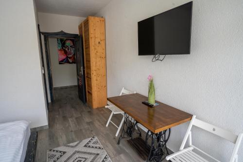 a room with a table and a television on the wall at Bârlogul Vikingilor in Şotrile