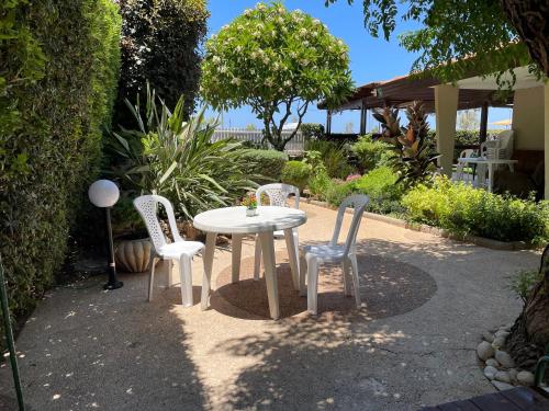 a white table and chairs in a garden at Breezot Yam in Nahariyya