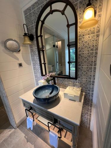 Un baño con lavabo y un espejo grande. en Nancy Grand Partea Villa, en Xã Thang Tam