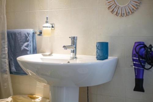 ein weißes Waschbecken im Bad mit Spiegel in der Unterkunft La casa di Olga e Terry in Uggiano la Chiesa