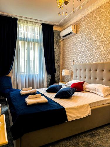 una camera da letto con un grande letto con cuscini sopra di Hotel Boutique Casa Vermont a Bucarest