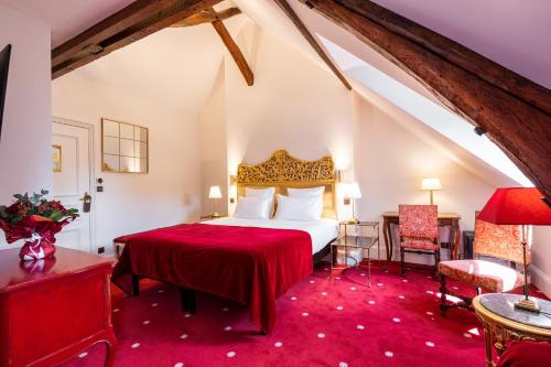 1 dormitorio con 1 cama con colcha roja en Le Manoir Saint Thomas, en Amboise