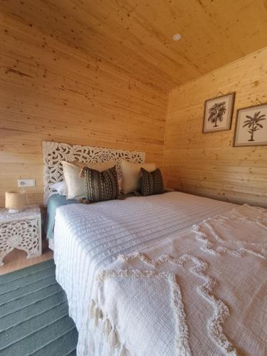 ein Schlafzimmer mit einem großen Bett in einer Holzhütte in der Unterkunft Eco Lodge Villa das Alfarrobas com Piscina in Algoz
