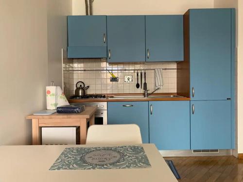 una piccola cucina con armadi blu e tavolo di Bilocale sull'acqua al Porto Antico a Genova