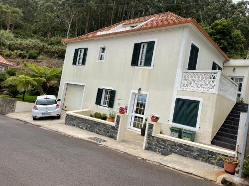 a white car parked in front of a house at Casa da Grota in Porto Moniz
