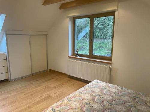 une chambre vide avec un lit et une fenêtre dans l'établissement Comfortable apartments - Nature, silence, coziness, à Kėdainiai