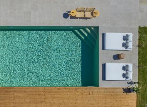 widok na basen z żółtym samochodem w obiekcie Athena Luxury Villa by Estia w mieście Gázion